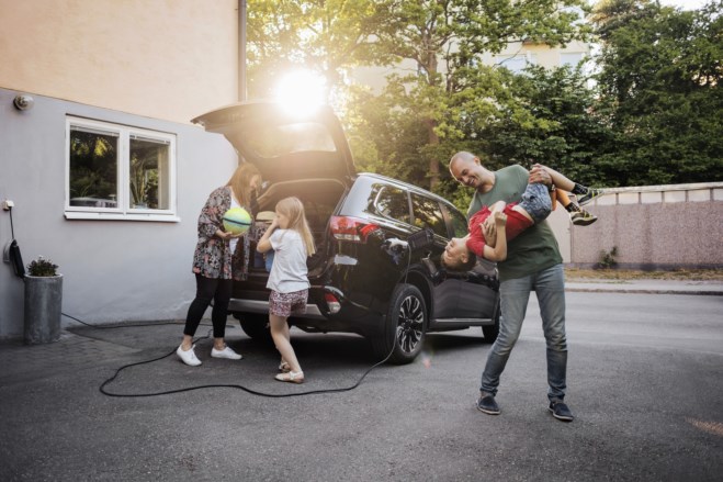Familie tøyser ved elbilen sin